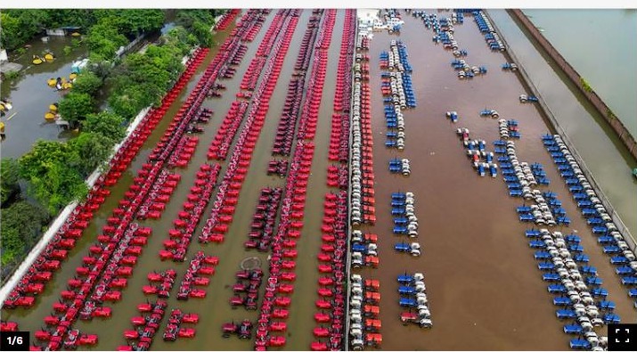 Tractors partially submerged in floodwaters at a dealership stockyard in Patna